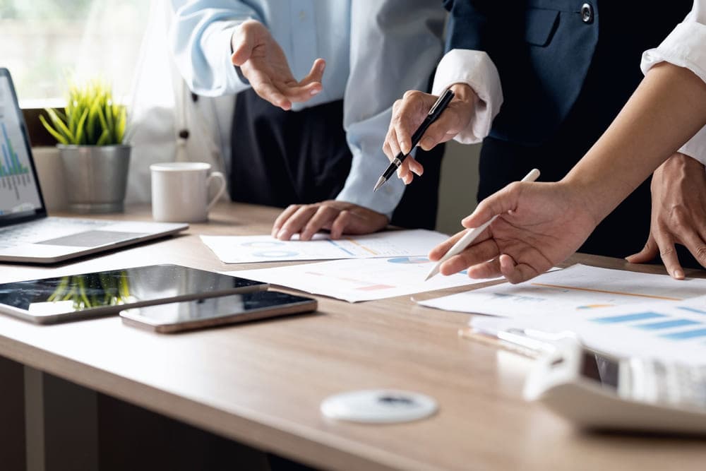 Professionals reviewing budget charts and documents at a desk