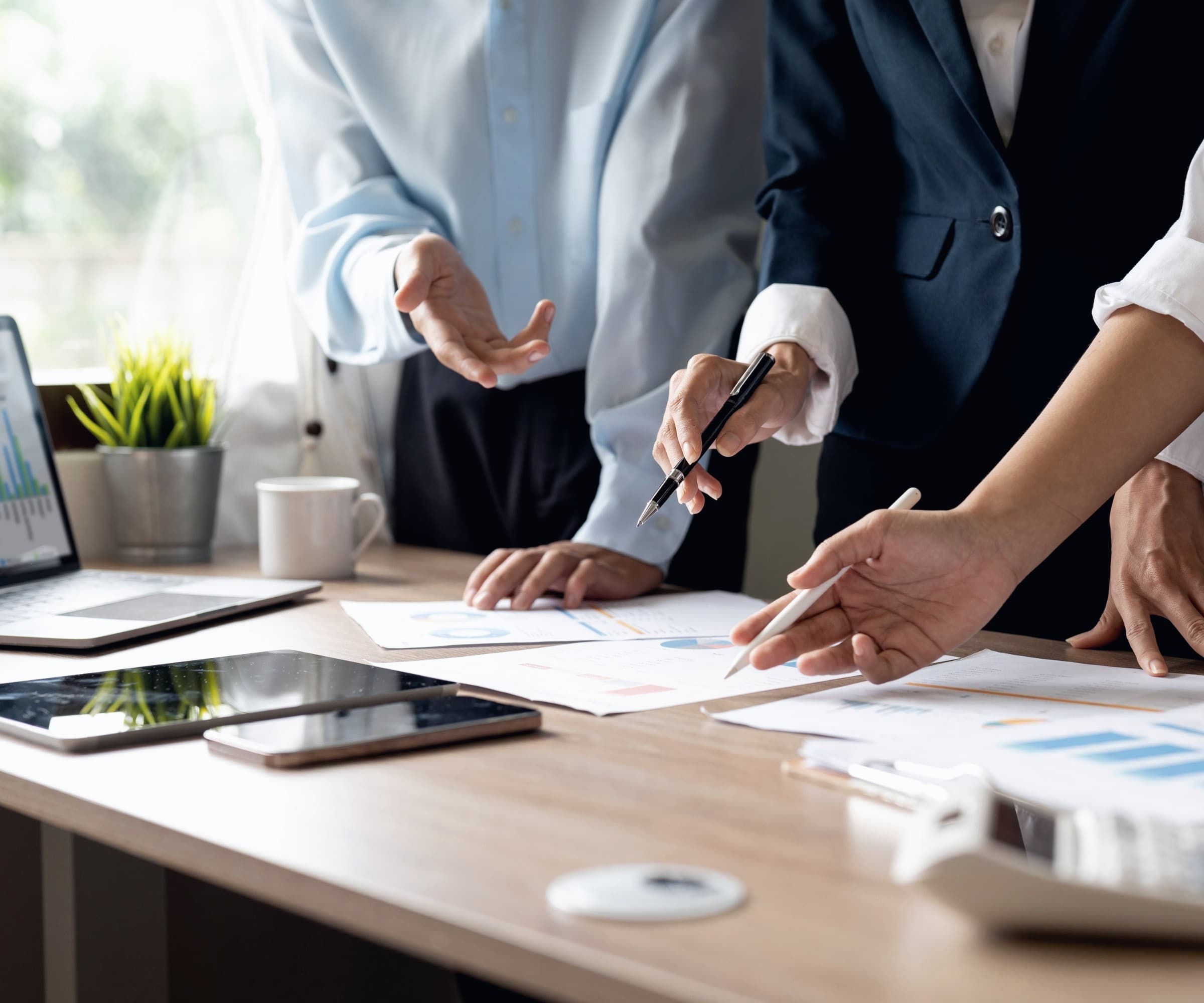 Professionals reviewing budget charts and documents at a desk.