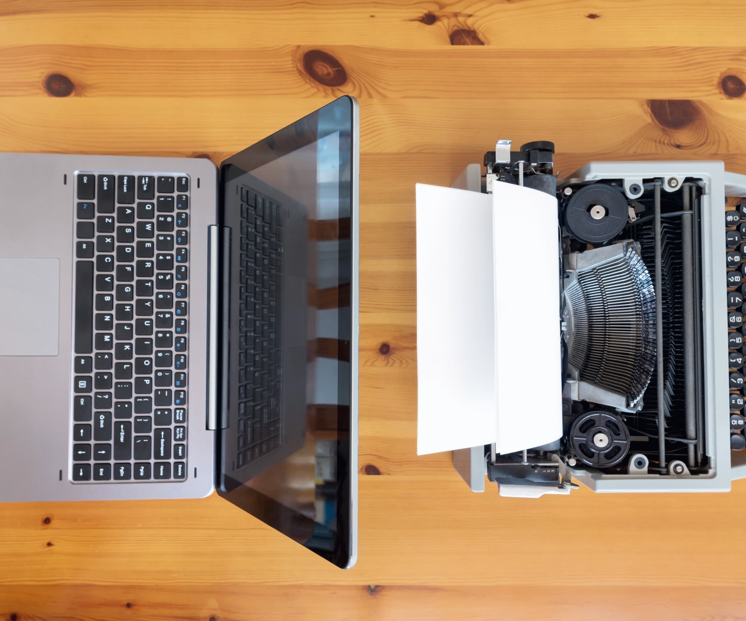 A laptop and a vintage typewriter side by side, symbolizing modernization.